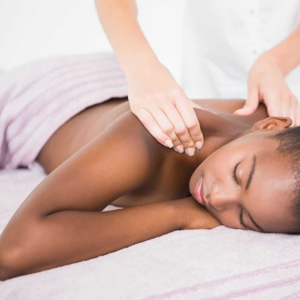 A woman receiving a back massage at a spa.