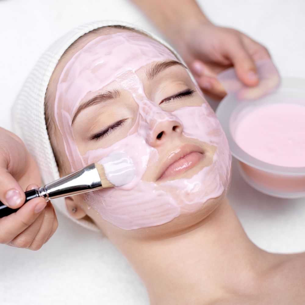 Person receiving a facial mask treatment at a spa.